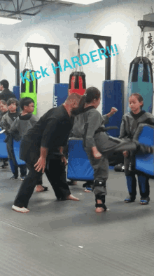 a group of kids are practicing martial arts with a sign that says kick harder !!!