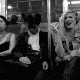 a woman wearing headphones laughs while sitting next to a man