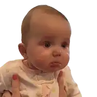 a baby is being held in someone 's arms and making a face