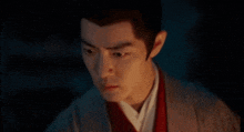 a close up of a man 's face in a dark room looking at the camera .