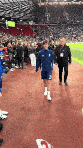 a soccer player with the number 2 on his shorts is walking on the field