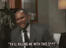 a man in a suit and tie is sitting in a chair and talking .