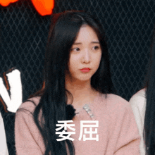 a girl in a pink sweater with chinese writing on her face