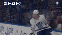 a hockey player in a toronto maple leafs jersey stands on the ice