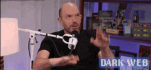 a man is sitting in front of a microphone with the words dark web on the bottom