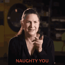 a woman is smiling and pointing at the camera with the words naughty you below her