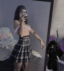 a girl taking a selfie in front of a mirror with a reflection of a person in a hoodie