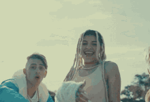 a man and a woman standing next to each other smiling