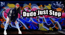 a woman is standing in front of a wall with graffiti and the words dude just stop above her