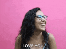 a woman wearing glasses is smiling and says `` love you '' .