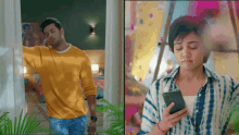 a man in a yellow shirt is standing next to a woman in a tie dye shirt looking at her phone