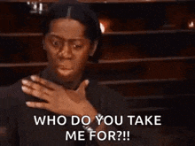 a woman is holding her hand to her chest and asking who do you take me for .