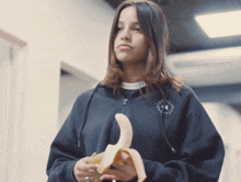 a girl wearing a black sweatshirt that says ' stella mccartney ' on it