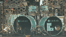 a man stands in front of a sakae one on rock drum set