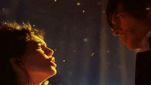 a man and a woman are looking at each other in the dark