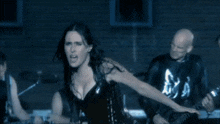 a woman in a corset is holding a guitar in front of a man