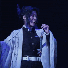 a woman in a black and white costume holds a sword in her hand