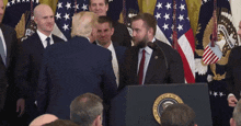 a man standing in front of a podium that has the seal of the president of the united states on it