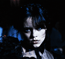 a close up of a woman 's face with a dark background