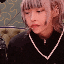 a girl with a piercing in her lip is wearing a black shirt