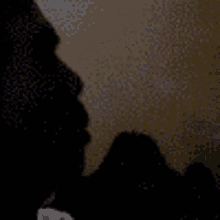 a silhouette of a person smoking a cigarette in a dark room