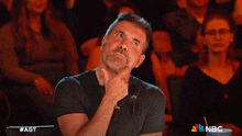 a man is sitting in front of a sign that says agt