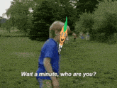 a boy in a blue shirt is standing in a grassy field with the words wait a minute who are you on the bottom