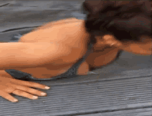 a woman is doing push ups on a mat