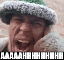 a man wearing a hat and a jacket is screaming with the words aaaah written on the bottom .