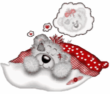 a teddy bear laying on a pillow with a thought bubble above it