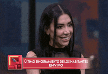 a woman is smiling in front of a banner that says " ultimo sinceramiento de los habitantes en vivo "