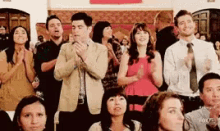 a group of people are clapping and applauding at a party
