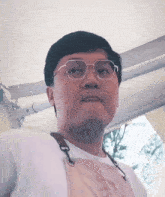 a man wearing glasses and an apron looks to the side