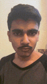 a man with a mustache is wearing a black and green shirt