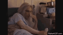 an elderly woman is sitting in bed holding a bottle of pills .