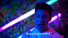 a man is standing in front of a crowd and saying " but you keep me wanting "