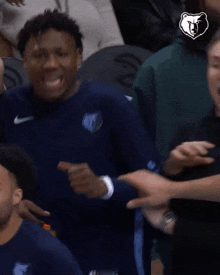 a man wearing a blue shirt with the word grizzlies on it is smiling