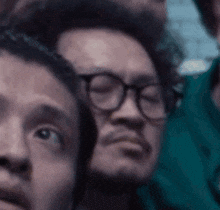 a close up of a man 's face with glasses