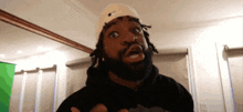 a man with dreadlocks wearing a hat that says ny