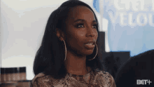 a woman in front of a sign that says bet +