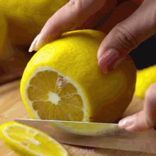 a person is cutting a lemon with a knife and the word mikes is on the bottom of the picture