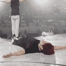 a person with red hair is laying on the floor