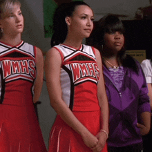 three cheerleaders wearing wmhs uniforms stand in a row