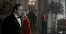 a man in a tuxedo is standing in a room with a netflix logo in the corner