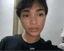 a close up of a young man 's face with the word jun written on it .