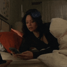 a woman is laying on a bed looking at her phone with a caption that says ritualya