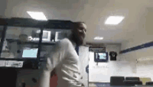 a man with a beard is dancing in a room with a lot of lights on the ceiling .