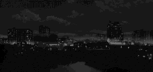 a black and white photo of a city with a river in the foreground