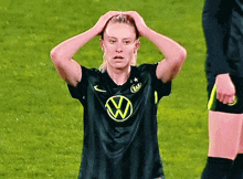 a female soccer player wearing a black shirt with a vw logo on the front