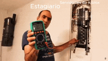 a man is holding a multimeter with the number 007 on the screen
